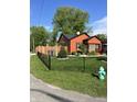 Charming house featuring wood fencing, lush green lawn, beautiful landscaping, and a vibrant green fire hydrant at 3302 N Gladstone Ave, Indianapolis, IN 46218