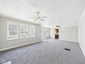 Open living room with fresh paint, carpet, multiple windows, and ceiling fan at 3631 Columbus Ave, Anderson, IN 46013
