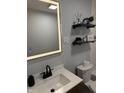 Modern bathroom with a well lit mirror, updated fixtures, floating shelves, and decorative elements at 3720 W 16Th St, Indianapolis, IN 46222