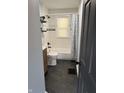 Renovated bathroom features a sleek, modern design with black hexagon flooring and a white tiled shower at 3720 W 16Th St, Indianapolis, IN 46222