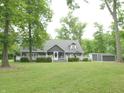 Charming gray home with a welcoming front porch, lush lawn, and mature trees creating a serene setting at 4363 E State Road 252, Franklin, IN 46131