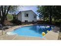 Backyard with a refreshing in-ground pool, surrounded by a concrete deck and mature trees at 492 Pelenor Dr, Franklin, IN 46131