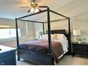 Bedroom features a dark wood four-poster bed with neutral bedding, side tables, and soft, natural lighting at 523 Torrey Ct, Avon, IN 46123