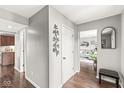 Bright hallway featuring hardwood floors, modern wall decor, and views into the living room and kitchen at 523 Torrey Ct, Avon, IN 46123