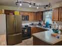 Well-lit kitchen with wood cabinets, stainless steel appliances, and a tile backsplash at 6006 Buell Ln, Indianapolis, IN 46254
