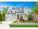 Stunning two-story home featuring a meticulously landscaped front yard and a three-car garage at 6734 W Stonegate Dr, Zionsville, IN 46077