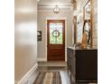 Charming hallway with hardwood floors, decorative mirror and cabinet, and a view to the front door at 6734 W Stonegate Dr, Zionsville, IN 46077