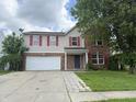 Two story home with brick and vinyl siding, red shutters, attached garage, and cloudy sky at 6903 Governors Pointe Blvd, Indianapolis, IN 46217
