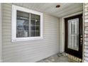 Covered front porch showcasing a door with decorative glass inserts and a window with white trim at 7642 Lancer Ln, Lawrence, IN 46226