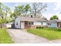 Cozy single-Gathering home with a driveway, manicured lawn, and a welcoming front entrance at 8144 E 50Th St, Indianapolis, IN 46226