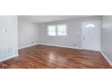 Bright living room featuring hardwood floors, a window, and a white front door at 8144 E 50Th St, Indianapolis, IN 46226