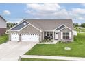 Beautiful single-story brick home with manicured lawn and three-car garage near a serene pond at 89 Kinnick Dr, Greenwood, IN 46143