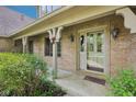 Inviting front porch features brickwork, tasteful light fixtures, and views of the surrounding greenery at 101 Applecross Dr, Brownsburg, IN 46112