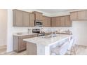 Modern kitchen featuring an island with seating, stainless steel appliances and marble countertops at 1107 Stubble Run, Danville, IN 46122