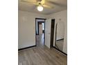An open door leads to the closet in this bedroom with wood-look flooring and a ceiling fan at 114 S Catherwood Ave, Indianapolis, IN 46219