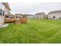 Expansive backyard with green grass and a wooden deck, perfect for outdoor entertaining at 11818 Bellhaven Dr, Fishers, IN 46038