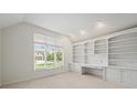 Office features custom built-ins, large window, and neutral carpet at 12739 Kiawah Dr, Carmel, IN 46033