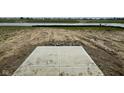 Backyard view showing a concrete platform and muddy landscaping that overlooks the pond at 1335 Foxtail Ln, Greenwood, IN 46143