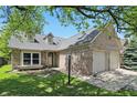 Charming brick home with a well-manicured lawn and an attached two-car garage at 14634 Village Park East Dr, Carmel, IN 46033