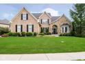 Charming brick and stone home with a lush green lawn and professionally landscaped front yard at 14707 Thor Run Dr, Fishers, IN 46040