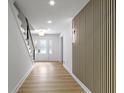 Bright entryway featuring hardwood floors, a decorative wall, and a staircase at 16 Maplecrest Dr, Carmel, IN 46033