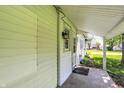 Covered porch with concrete floor on the side of the house with a single outdoor light at 1610 S F St, Elwood, IN 46036
