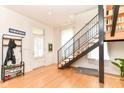 Bright entryway with hardwood floors, black metal staircase, coat rack, and natural light at 1630 N New Jersey St, Indianapolis, IN 46202