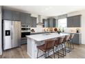 Modern kitchen with gray cabinets, stainless steel appliances, white countertops, and stylish bar stools at 175 Rock Island Rd, Westfield, IN 46074