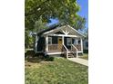 Inviting home with a cozy front porch and a bright yellow door at 2009 Draper St, Indianapolis, IN 46203