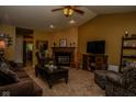 Open living room with fireplace, ceiling fan, comfortable seating, and neutral carpet at 270 Rapid Rill Ln, Brownsburg, IN 46112