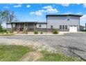 Stunning gray two-story home with a covered porch, ramp, and a gravel driveway at 3682 S 380 E, Anderson, IN 46017