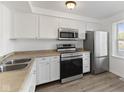 Bright kitchen featuring white cabinetry, stainless steel appliances, and wood-look vinyl flooring at 3705 Lima Ct, Indianapolis, IN 46227