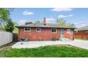 Spacious backyard featuring a patio, lush grass, and a classic brick exterior of the home at 4213 N Audubon Rd, Indianapolis, IN 46226