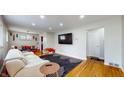 Cozy living room features hardwood floors, a comfy couch, and a dining area at 4213 N Audubon Rd, Indianapolis, IN 46226
