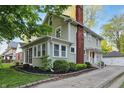 Charming two-story home boasts a brick chimney and well-maintained landscaping at 4447 N College Ave, Indianapolis, IN 46205