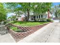 Charming two-story home featuring a well-manicured lawn and a paved driveway at 4447 N College Ave, Indianapolis, IN 46205