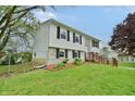 Split-level home boasts manicured lawn, vinyl siding and a brick accent, set in a peaceful residential area at 4527 Peachwood Ct, Indianapolis, IN 46235