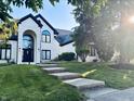 Charming two-story home with a manicured lawn and mature trees surrounding the property at 4601 Fairhope Dr, Indianapolis, IN 46237