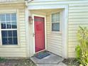 Home's front entrance, showcasing a red door, decorative lighting, and well-maintained landscaping at 4947 Peony Pl, Indianapolis, IN 46254