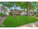 Charming brick home featuring a well-maintained lawn and mature trees in a quiet neighborhood at 4956 W 11Th St, Speedway, IN 46224