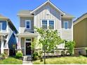 Beautiful two-story home featuring neutral siding, a welcoming front porch, and a landscaped yard at 5755 Buskirk Dr, Indianapolis, IN 46216