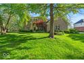 Charming two-story brick home with mature trees and lush green lawn at 5783 Coopers Hawk Dr, Carmel, IN 46033