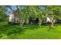 Charming two-story brick home with mature trees and lush green lawn at 5783 Coopers Hawk Dr, Carmel, IN 46033