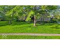 Charming two-story brick home with mature trees and lush green lawn at 5783 Coopers Hawk Dr, Carmel, IN 46033