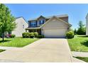 Charming two-story home with a well-manicured lawn, two-car garage, and inviting curb appeal at 5827 High Grass Ln, Indianapolis, IN 46235