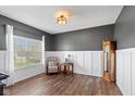 Bright home office with wood floors, white wainscoting, gray walls, and a large window for natural light at 695 Bobtail Dr, Greenfield, IN 46140