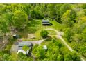 Scenic aerial shot reveals the home surrounded by lush trees, buildings, and a circular driveway at 6968 S 300 W, Trafalgar, IN 46181