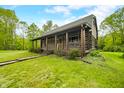 Quaint log cabin home with a covered front porch and stone walkway amidst a lush green lawn and mature trees at 6968 S 300 W, Trafalgar, IN 46181