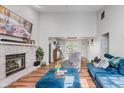 Open-concept living room with high ceilings, a brick fireplace, and large windows with natural light at 7606 Old Oakland Blvd E Dr, Indianapolis, IN 46236
