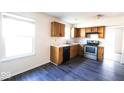 Galley kitchen features stainless steel appliances, wood cabinets, and a window above the sink at 7611 Misty Meadow Dr, Indianapolis, IN 46217